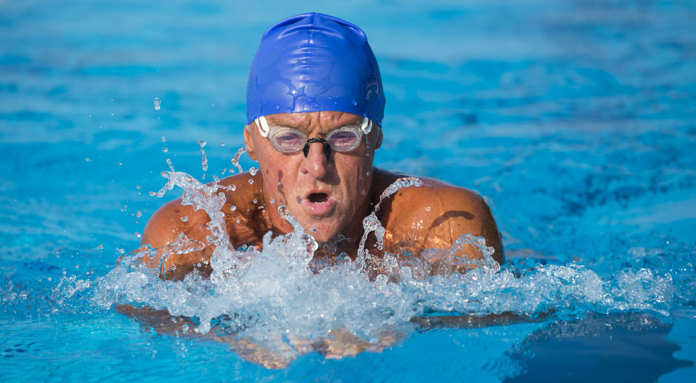 A senior man swims in a pool in Athens, GA.